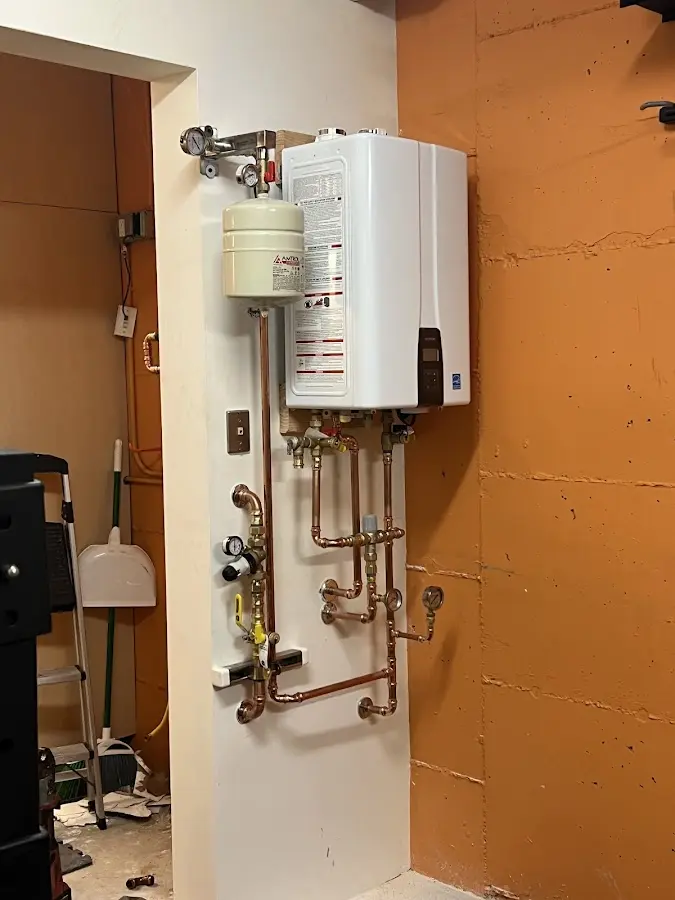 Plumbing technician inspecting water heater connections in Kyle